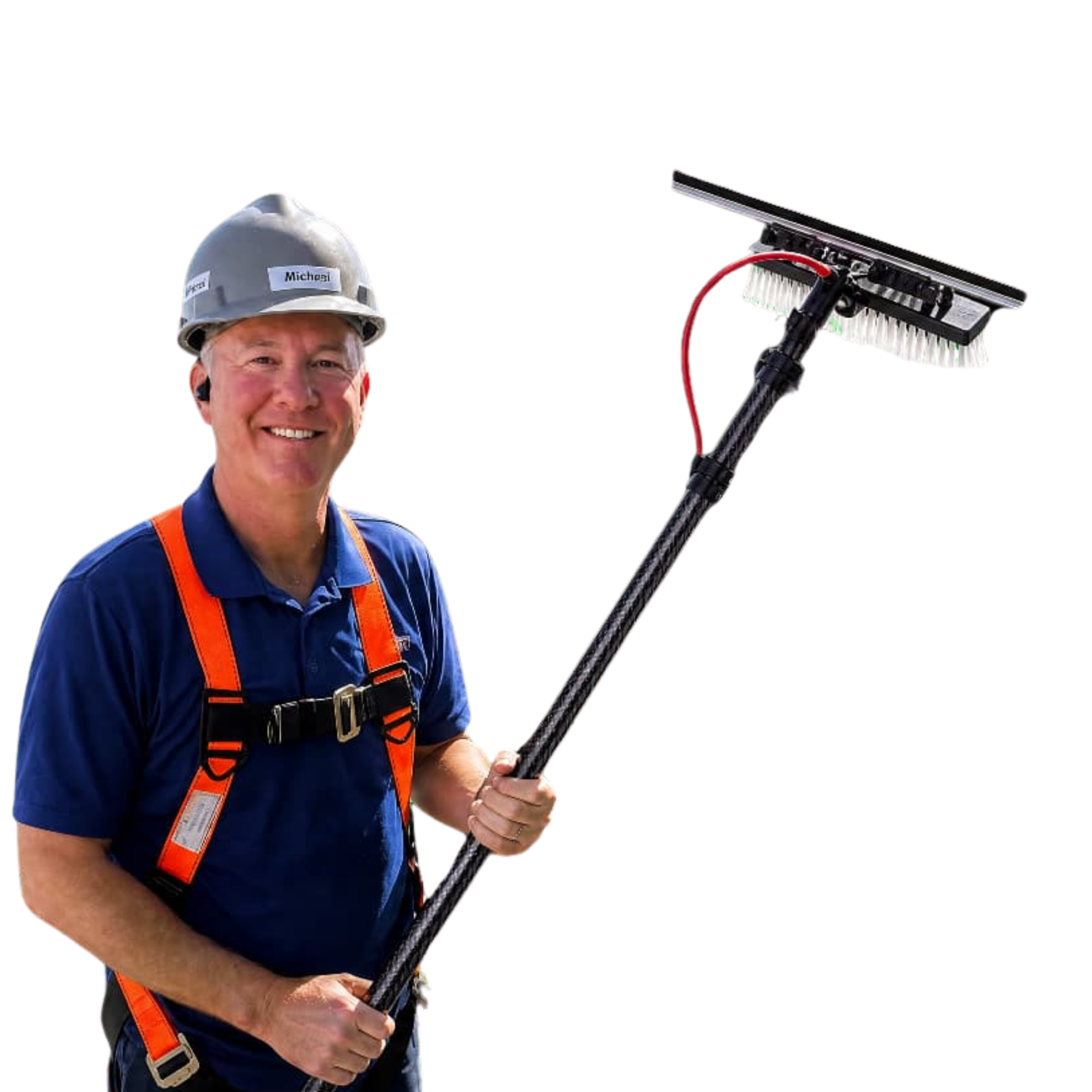 A smiling professional window cleaner wearing a safety harness and hard hat, standing in an aerial lift holding a carbon-fiber water-fed pole brush for commercial building cleaning.