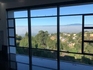 Reflection-free, streak-free windows inside a multi-story commercial apartment building after being cleaned by Spotfree Window, with dramatic clouds visible outside.