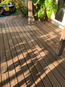 A clean, dry wooden deck with visible grain after a professional power washing by Spotfree Window.