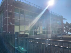 A brick commercial building with large windows reflecting the sun after being cleaned by Spotfree Window's professional service.