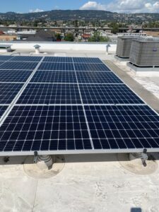 A beautiful view of a large commercial solar panel array after professional cleaning by Spotfree Window, reflecting the blue sky and clouds.