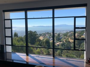 Clean, gleaming glass panels inside a commercial residential complex, offering an unobstructed view of the bay and hills after a professional cleaning by Spotfree Window.