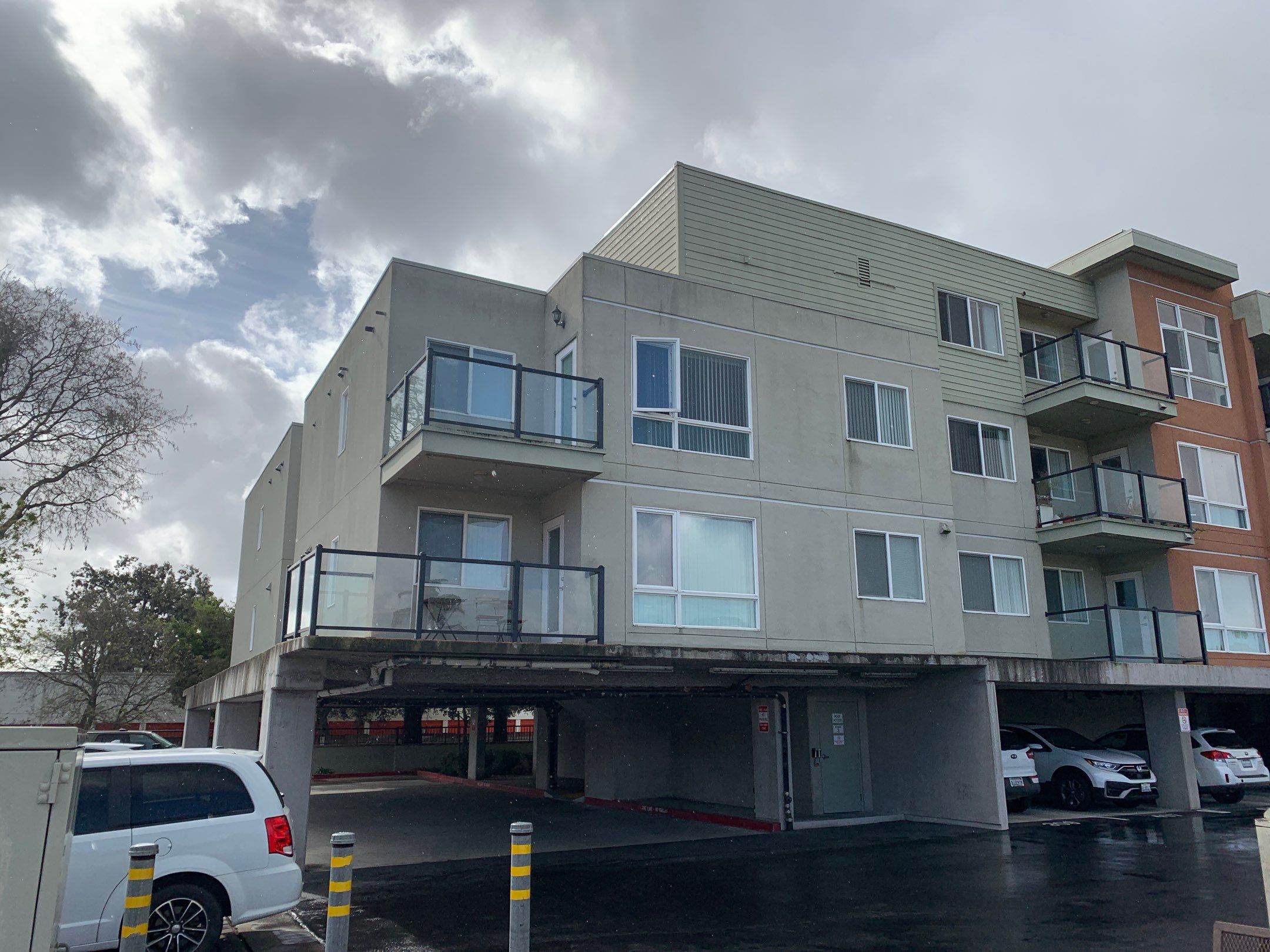 A commercial residential building with covered parking below, highlighting the need for professional commercial window cleaning across all levels.