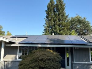 A clean commercial solar panel array on a flat roof next to HVAC units and vents, cleaned by Spotfree Window.