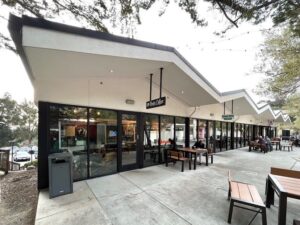 A sunny patio area outside a business with large glass floor-to-ceiling windows cleaned by Spotfree Window to enhance the customer experience.