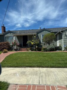 A beautiful green single-story home with a red brick walkway, green lawn, and freshly washed exterior after a complete whole house wash by Spotfree Window.