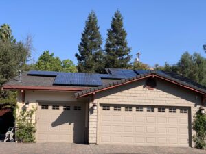 A beige home with a beige garage and rooftop solar panels, expertly cleaned by a whole house washing service from Spotfree Window.